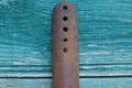 Old long iron plate in brown rust with a row of holes