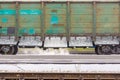 old and long unpainted railway wagon for bulk cargo finishes unloading rubble Royalty Free Stock Photo