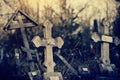 Old lop-sided sepulchral crosses on the thrown graves at the cemetery.