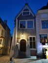 An old low building with an original entrance and a beautiful lantern above it in the city center against the blue sky. Old