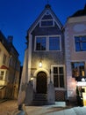 An old low building with an original entrance and a beautiful lantern above it in the city center against the blue sky. Old