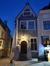 An old low building with an original entrance and a beautiful lantern above it in the city center against the blue sky. Old