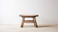 Old low Chinese wooden stool in an empty room with white wall and floor. Traditional craft, handmade furniture. Generative AI Royalty Free Stock Photo