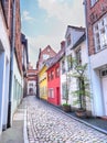 Old Lubeck street with paving stone. Small trees growing in pots Royalty Free Stock Photo