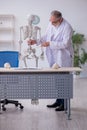 Old male anatomy teacher demonstrating human skeleton