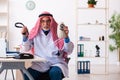 Old male arab doctor holding moneybag