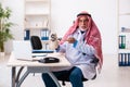 Old male arab doctor holding moneybag