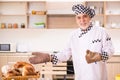 Old male baker working in the kitchen Royalty Free Stock Photo