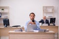 Old male boss and young employee working in the office Royalty Free Stock Photo