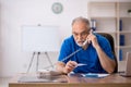 Old male doctor holding thermometer in the clinic Royalty Free Stock Photo