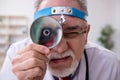 Old male doctor otologist working in the clinic