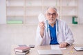 Old male doctor wearing mask in the clinic Royalty Free Stock Photo