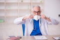 Old male doctor wearing mask in the clinic Royalty Free Stock Photo