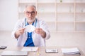 Old male doctor wearing mask in the clinic Royalty Free Stock Photo