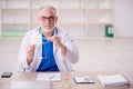 Old male doctor wearing mask in the clinic Royalty Free Stock Photo