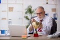 Old male employee being awarded with golden cup Royalty Free Stock Photo