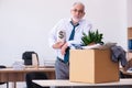 Old male employee being fired from his work in retirement concept