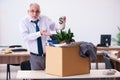 Old male employee being fired from his work in retirement concept