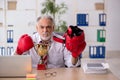 Old male employee boxer being awarded with golden cup