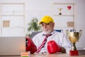 Old male employee boxer being awarded with golden cup