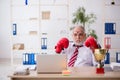 Old male employee boxer being awarded with golden cup