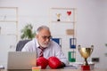 Old male employee boxer being awarded with golden cup