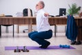 Old businessman employee doing sport exercises in the office Royalty Free Stock Photo