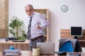 Old male employee suffering from radiculitis at workplace