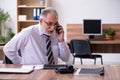 Old male employee suffering from radiculitis at workplace