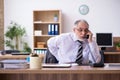 Old male employee suffering from radiculitis at workplace