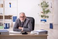 Old male employee working in the office Royalty Free Stock Photo