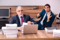 Old male employer and young male assistant in bullying concept Royalty Free Stock Photo