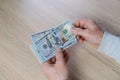 Old male hands hold paper dollars banknotes in his hands, counting a bundle of money, concept of cash, payments, savings Royalty Free Stock Photo