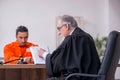 Old male judge meeting with young captive in courthouse