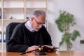 Old male judge working in courthouse