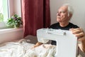Old male man senior sit next at table at home work, sewing machine enjoy Royalty Free Stock Photo
