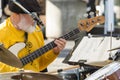 Old male musician playing guitar and drums