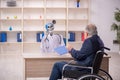 Old patient in wheel-chair visiting devil doctor Royalty Free Stock Photo