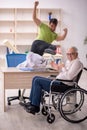 Old patient in wheel-chair visiting skeleton doctor Royalty Free Stock Photo