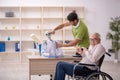 Old patient in wheel-chair visiting skeleton doctor Royalty Free Stock Photo