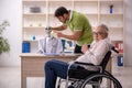 Old patient in wheel-chair visiting skeleton doctor Royalty Free Stock Photo