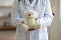 Old male pediatrician holding teddy bear in hands, close up Royalty Free Stock Photo