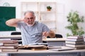 Old male student being exhausted during exam preparation