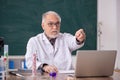 Old male teacher chemist sitting in the classroom