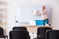 Old male teacher in the classroom in pandemic concept Royalty Free Stock Photo