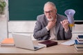 Old male teacher holding megaphone in front of blackboard Royalty Free Stock Photo