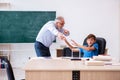 Old male teacher and schoolboy in the classroom