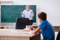 Old male teacher and schoolboy in the classroom