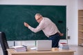 Old male teacher sitting in the classroom Royalty Free Stock Photo