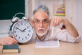 Old male teacher in time management concept Royalty Free Stock Photo